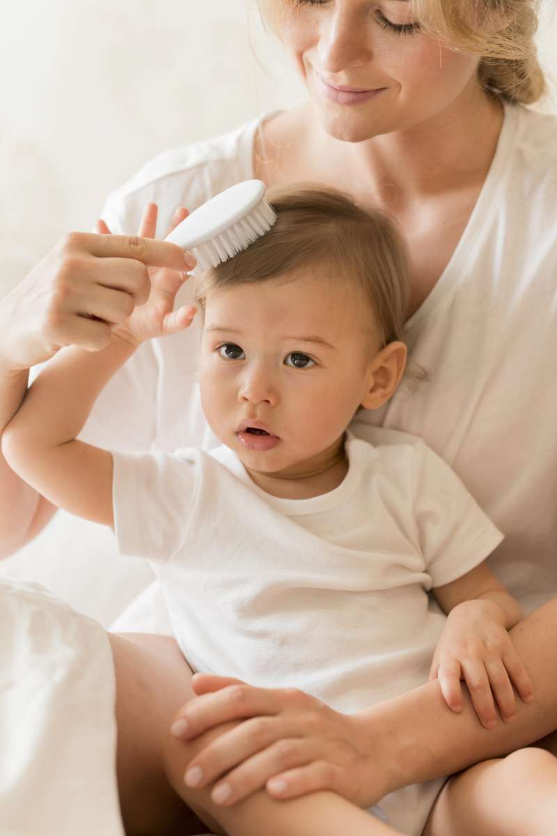 Madre peinando a su bebé