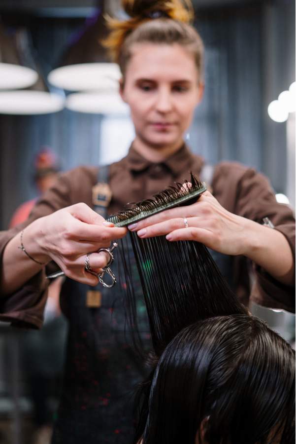 Peluquera realizando corte de pelo media melena